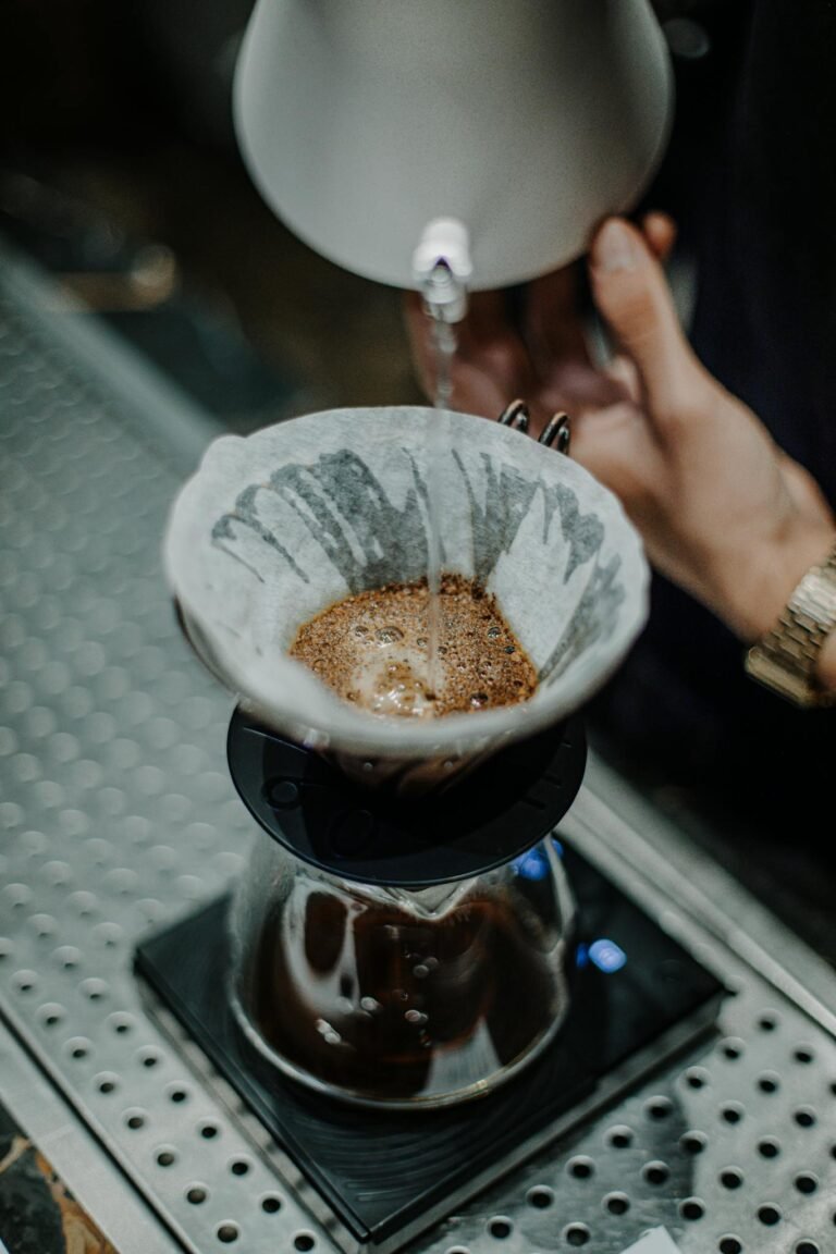 Close-up of hand pouring hot water over coffee in a filter in Baku, Azerbaijan.